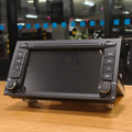 Car stereo system on a wooden surface with a blurred indoor background
