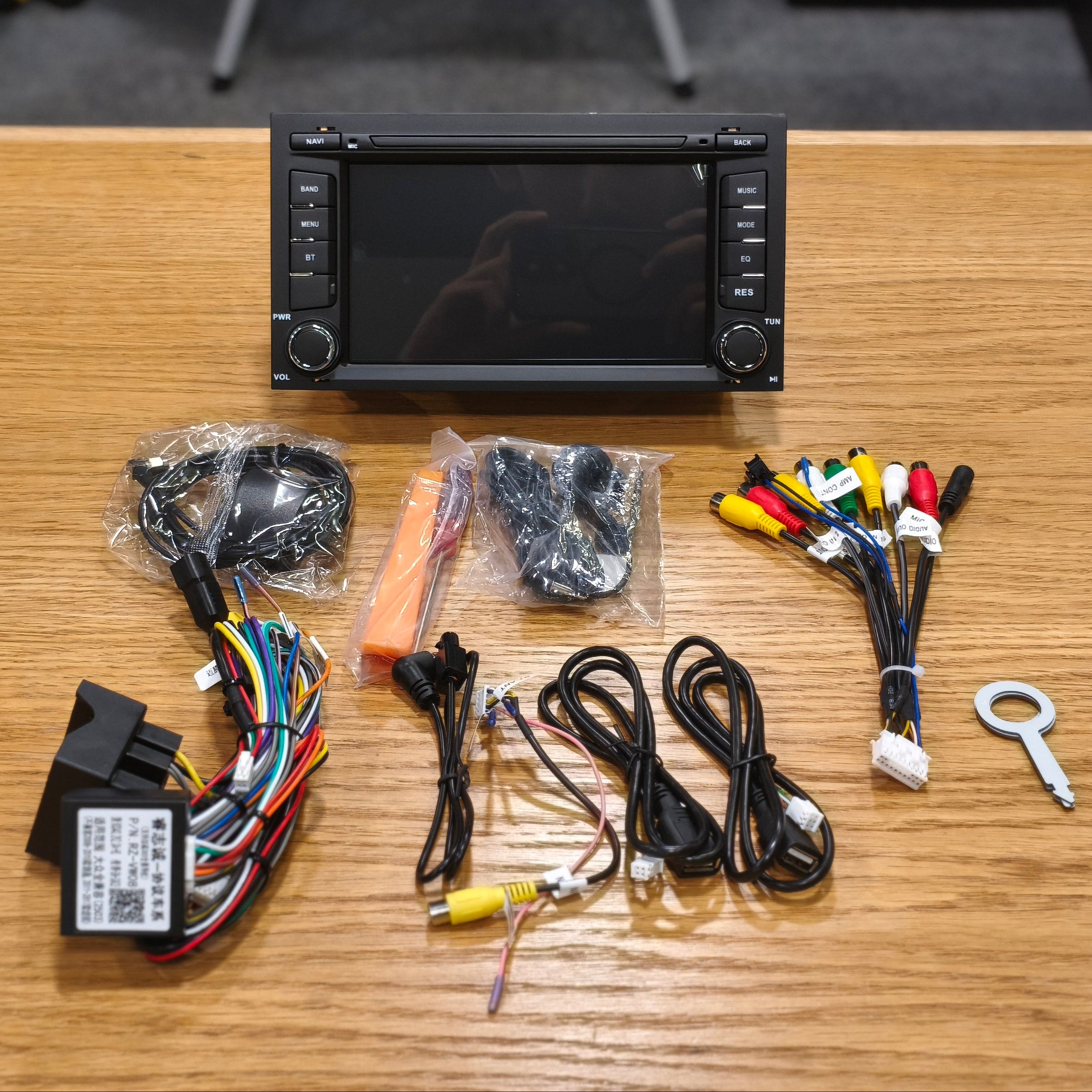 Car stereo kit with wiring harnesses and connectors on a wooden table.